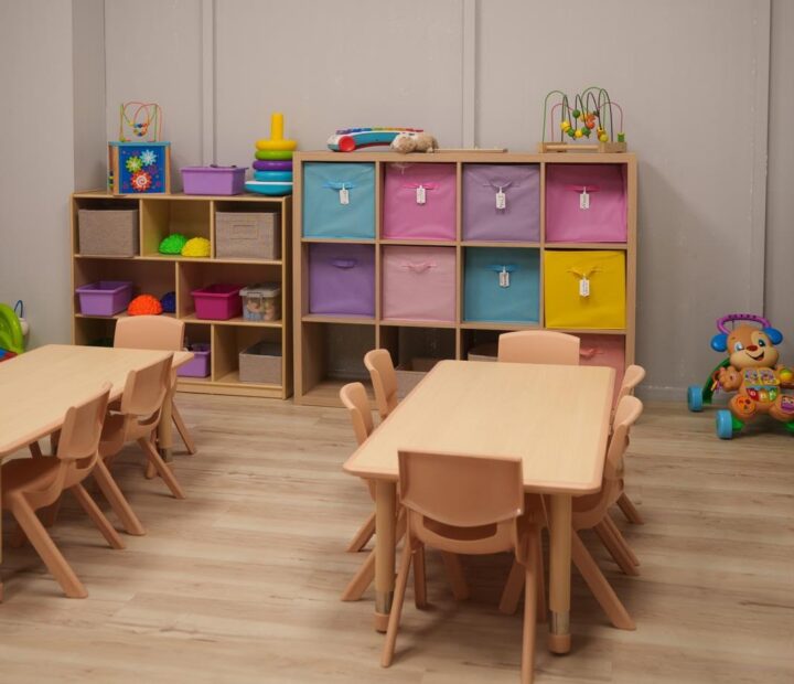 Organized classroom with child-sized tables and colorful storage