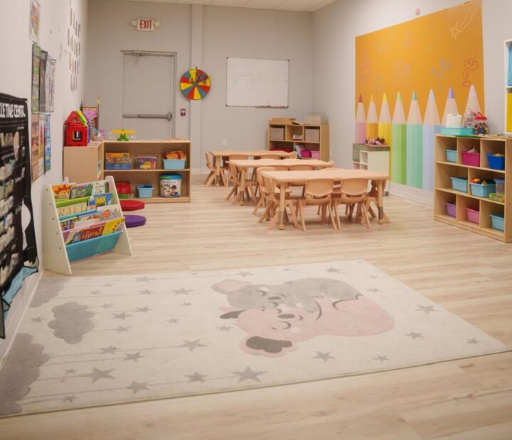 Bright preschool classroom with learning tables, books and activity areas